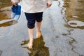 Woman walking on flooding road with holding shoes after the heavy rains,cause of itchy skin include,be careful of leptospirosis,it