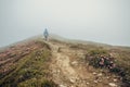 Woman walking in foggy mountain path Royalty Free Stock Photo