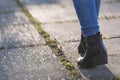 Woman walking forward in the park, moving feet in leather boots at sunset. Leisure activity, walking concept