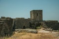 Woman walking in front of stone wall at the Castle of Monsanto