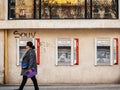 Woman walking in front of three vandalized ATM