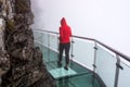 Woman walking on glass Sky Walk at Tianmen Mountain,  mist, Zhangjiajie, Hunan, China Royalty Free Stock Photo