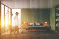 Woman walking in green master bedroom