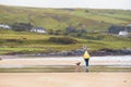 Woman walking with her dog on a beach by the ocean, Selective focus. Play time with your adorable pet concept