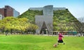 Woman walking with her dog in front of ACROS Fukuoka Prefectural International Hall at Tenjin Central Park, Fukuoka, Japan, Royalty Free Stock Photo