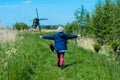 Woman walking her dog near Dutch windmill