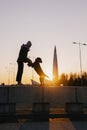 woman walking her dog at sunset, beautiful sunset against the background of modern buildings Royalty Free Stock Photo