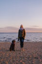 woman walking her dog at sunset, beautiful sunset against the background of modern buildings Royalty Free Stock Photo