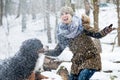 Woman walking her dog in the winter and both explore the snow to Royalty Free Stock Photo