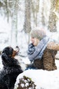 Woman walking her dog in the winter and both explore the snow to Royalty Free Stock Photo