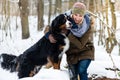 Woman walking her dog in the winter and both explore the snow together Royalty Free Stock Photo