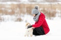 Woman walking her dog in the winter and both explore the snow together in playful mood Royalty Free Stock Photo