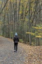 woman walking on a hiking trail in Taughannock Falls State Park wearing brown jacket, hat Royalty Free Stock Photo