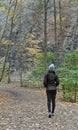 woman walking on a hiking trail in Taughannock Falls State Park wearing brown jacket, hat Royalty Free Stock Photo