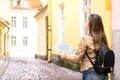 Woman walking and holding map in the city street. Royalty Free Stock Photo