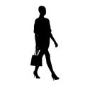 Woman walking with small handbag on her shoulder, isolated vector silhouette, side view Royalty Free Stock Photo