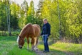 Woman walking with horse in summer in Finland Royalty Free Stock Photo