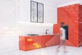 Woman walking in kitchen with orange countertops Royalty Free Stock Photo