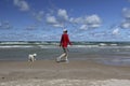 Woman Walking on a Lake Huron Beach with a Small White Dog