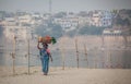 A woman is walking with laundry basket on her head Royalty Free Stock Photo