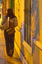 Woman walking on Miraflores sidewalk at night with shadows