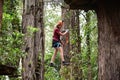 Woman walking on narrow cable line during a treetop adventure climbing