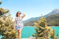 Woman walking in nature, mountain in the background. Adventure, freedom and carefree lifestyle. Millennial lady in summer dress.