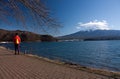 A woman walking near Lake Kawaguchi in Japan, Mount Fuji in the distance on a sunny spring day Royalty Free Stock Photo