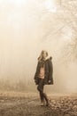 Woman walking in park in foggy day Royalty Free Stock Photo