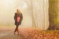 Woman walking in park in foggy day Royalty Free Stock Photo