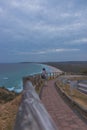 Woman walking on pathway of coast