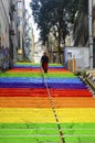 Woman is walking in the rainbow-colored stairs