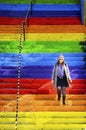 Woman is walking in the rainbow-colored stairs