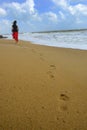 Woman walking on the sand of the beach Royalty Free Stock Photo