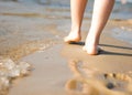Woman walking on sand beach leaving footprint in the sand. Beach travel