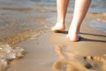 Woman walking on sand beach leaving footprint in the sand. Beach travel