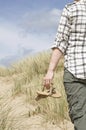 Woman walking in sand dunes holding sandals Royalty Free Stock Photo