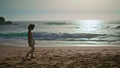 Woman walking sand seashore enjoying summer sunrise. Girl going near ocean waves