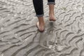 Woman walking on sandy beach leaving footprints in the beach