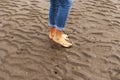 Woman walking on sandy beach leaving footprints in the beach