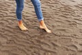 Woman walking on sandy beach leaving footprints in the beach