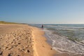 Woman walking on sandy beach in sunset