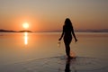 Woman walking in sea at sunset Royalty Free Stock Photo