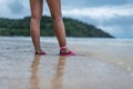 A woman walking in the shallows on the beach Royalty Free Stock Photo