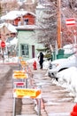 Woman walking on the sidewalk of a road with barricades and no parking signs