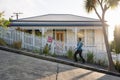 Woman walking in the steepest street in the world. Baldwin Street in Dunedin, New Zealand. November 2020