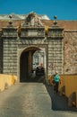 Woman walking a street going toward a city wall gateway