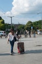 Woman walking with suitcase in front of train station in Mulhouse Royalty Free Stock Photo