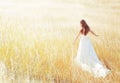 Woman walking in the sunny meadow on summer day