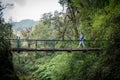 Woman walking on suspended wooden bridge in jungle, Sapa, Vietnam Royalty Free Stock Photo